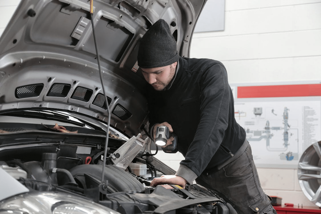  A Photo of Man Inspecting Car Engine